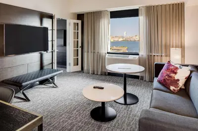 a hotel room with a couch and a tv at DoubleTree by Hilton Hotel & Suites Jersey City in Jersey City