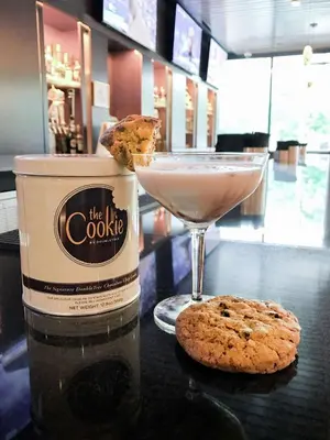a cookie and a drink sitting on a table at DoubleTree by Hilton Hotel & Suites Jersey City in Jersey City