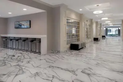 a lobby with marble flooring and a large room with chairs at DoubleTree Suites by Hilton Mount Laurel in Mount Laurel