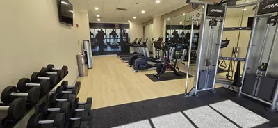 a gym with treadmills and exercise equipment and chairs at DoubleTree Suites by Hilton Mount Laurel in Mount Laurel