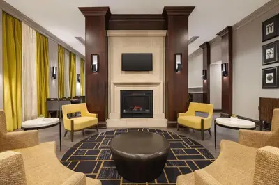 a lobby with a fireplace and yellow chairs at Homewood Suites by Hilton Philadelphia-City Avenue in Philadelphia