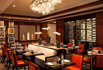 a restaurant with tables and chairs and a chandelier at Hilton Short Hills in Short Hills
