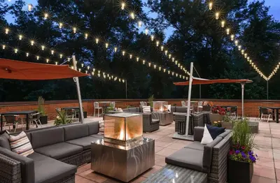 a patio with couches and tables and lights at Hilton Short Hills in Short Hills