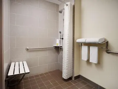 a bathroom with a shower with a bench and towels at DoubleTree by Hilton Hotel Philadelphia Center City in Philadelphia