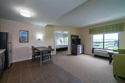 a hotel room with a desk and a bed and a bedroom at Hampton Inn & Suites Valley Forge/Oaks in Phoenixville