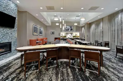 a conference room with a large table and chairs and a fireplace at Homewood Suites by Hilton Edgewater-NYC Area in Edgewater