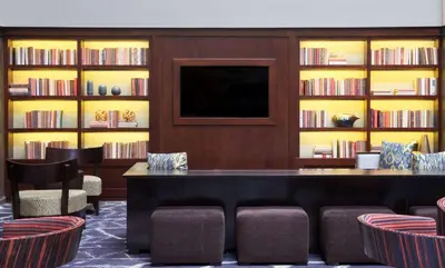 a library with a table and chairs and books at Embassy Suites by Hilton Philadelphia Airport in Philadelphia
