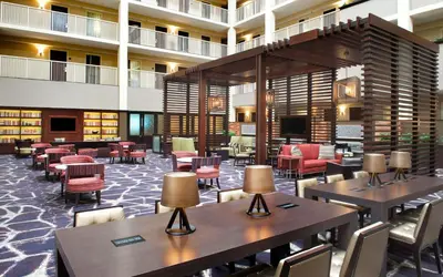 a hotel lobby with tables and chairs and books at Embassy Suites by Hilton Philadelphia Airport in Philadelphia