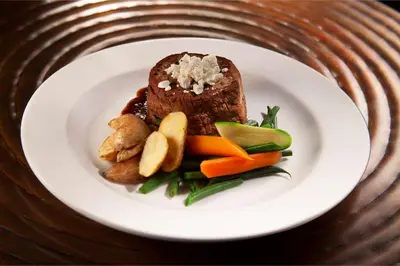 a plate of food with meat and vegetables on a table at Embassy Suites by Hilton Philadelphia Airport in Philadelphia