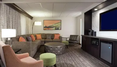 a living room with a couch and a flat screen tv at Embassy Suites by Hilton Philadelphia Airport in Philadelphia