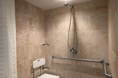 a bathroom with a shower with a toilet at Embassy Suites by Hilton Philadelphia Airport in Philadelphia