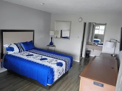 a bedroom with a bed with a blue and white blanket at Bel Air Motor Lodge in Maple Shade