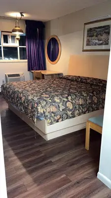 a bedroom with a bed and a table in it at Bel Air Motor Lodge in Maple Shade