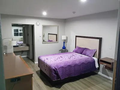 a bedroom with a purple bed and a sink at Bel Air Motor Lodge in Maple Shade