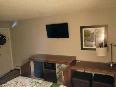 a bedroom with a desk and a television on the wall at Bel Air Motor Lodge in Maple Shade