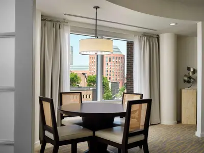 a dining room with a table and chairs and a window at The Inn at Penn, A Hilton Hotel in Philadelphia
