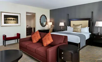 a hotel room with a couch and a bed at The Inn at Penn, A Hilton Hotel in Philadelphia