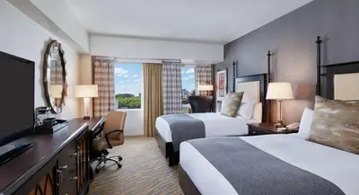 a hotel room with two beds and a television at The Inn at Penn, A Hilton Hotel in Philadelphia