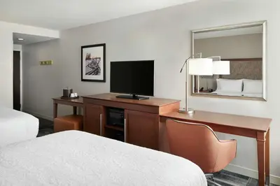a hotel room with a desk with a television and a bed at Hampton Inn Philadelphia/King of Prussia - Valley Forge in King of Prussia