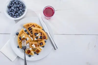 a plate of waffles and blueberries on a table at Hampton Inn Philadelphia/King of Prussia - Valley Forge in King of Prussia
