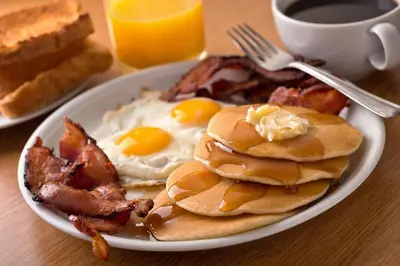 a plate of breakfast food with eggs and bacon at Hampton Inn Philadelphia/King of Prussia - Valley Forge in King of Prussia