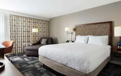 a hotel room with a bed and a chair at Hampton Inn Philadelphia/King of Prussia - Valley Forge in King of Prussia
