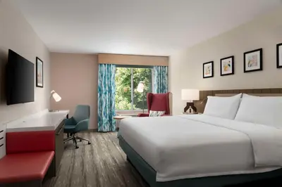 a hotel room with a large bed and a desk at Hilton Garden Inn Kennett Square in Kennett Square