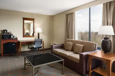 a hotel room with a couch and a table and a desk at DoubleTree by Hilton Hotel & Executive Meeting Center Somerset in Somerset