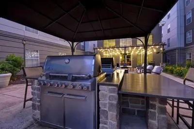 a grill in a patio with a table and a bar at Homewood Suites by Hilton Philadelphia-Great Valley in Malvern