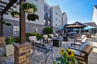 a patio with chairs and tables and a building at Homewood Suites by Hilton Philadelphia-Great Valley in Malvern