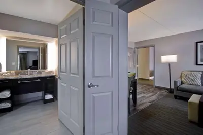 a room with a bathroom with a sink and a door at Homewood Suites by Hilton Philadelphia-Great Valley in Malvern