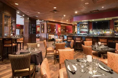 a restaurant with tables and chairs and a bar at Hilton Parsippany in Parsippany