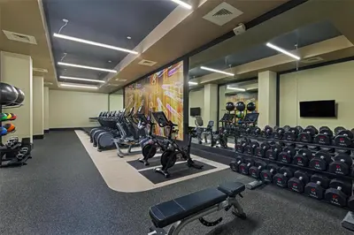 a gym with rows of tread machines and a large screen at Hilton Parsippany in Parsippany