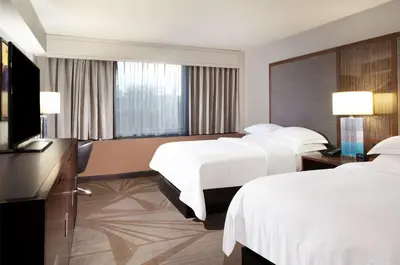 a hotel room with two beds and a flat screen tv at Hilton Parsippany in Parsippany