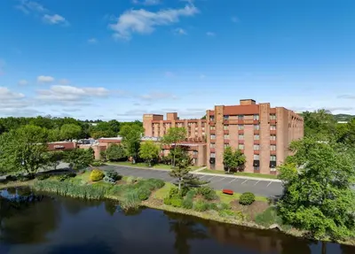 an aerial view of a building next to a river at Hilton Parsippany in Parsippany