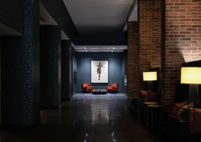 a lobby with red chairs and a picture of a woman at Hilton Parsippany in Parsippany
