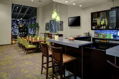 a bar in a restaurant with a table and chairs at Hilton Garden Inn New York/Manhattan-Chelsea in New York