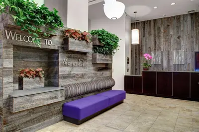 a lobby with a welcome to sign and a purple bench at Hilton Garden Inn New York/Manhattan-Chelsea in New York