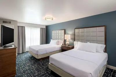 a hotel room with two beds and a flat screen tv at Homewood Suites by Hilton Mount Laurel in Mount Laurel