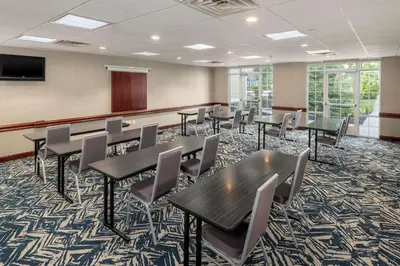 a conference room with tables and chairs and a podium at Homewood Suites by Hilton Mount Laurel in Mount Laurel