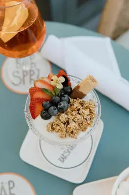 a bowl of fruit and granola on a table at Kimpton Theta New York - Times Square by IHG in New York