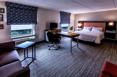 a hotel room with a bed and a desk at Hampton Inn & Suites Staten Island in Staten Island