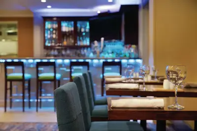 a restaurant with tables and chairs and a bar at Hilton Garden Inn Bridgewater in Bridgewater