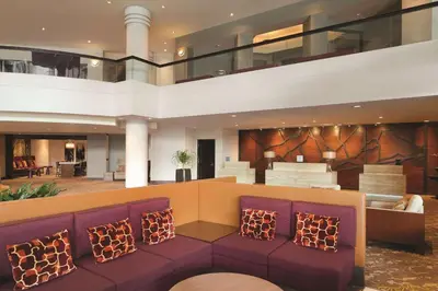 a lobby with purple chairs in a building at Hilton East Brunswick in East Brunswick