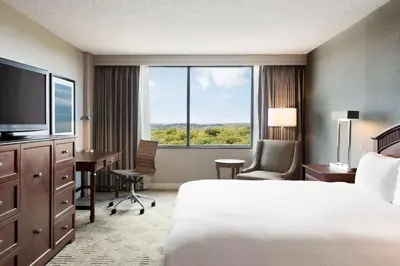 a hotel room with a bed and a desk and a television at Hilton East Brunswick in East Brunswick