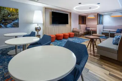 a waiting room with tables and chairs and a couch at Hampton Inn Harriman Woodbury in Central Valley