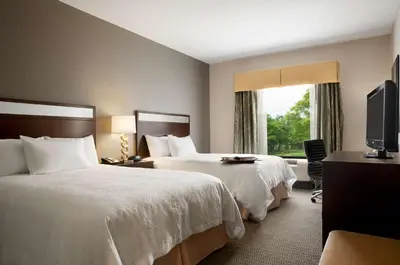 a hotel room with two beds and a television at Hampton Inn & Suites - Mansfield in Mansfield