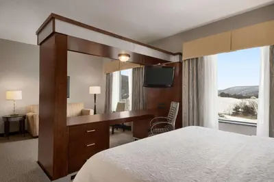 a hotel room with a desk and a large mirror at Hampton Inn & Suites - Mansfield in Mansfield
