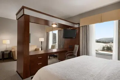 a hotel room with a desk and a large mirror at Hampton Inn & Suites - Mansfield in Mansfield