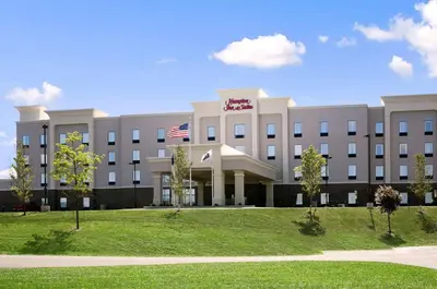 a building with an american flag in front of it at Hampton Inn & Suites - Mansfield in Mansfield